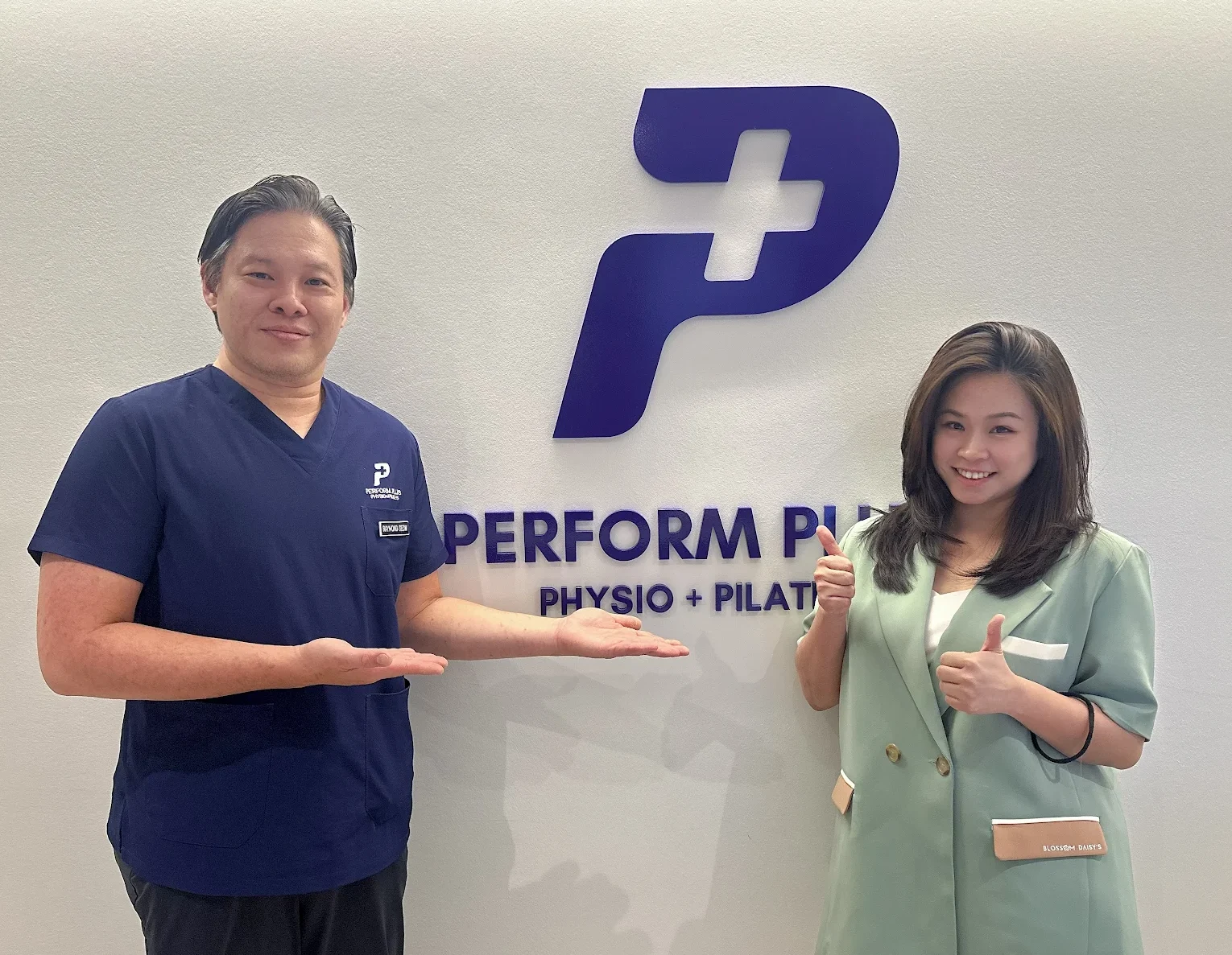 2 people standing in front of logo